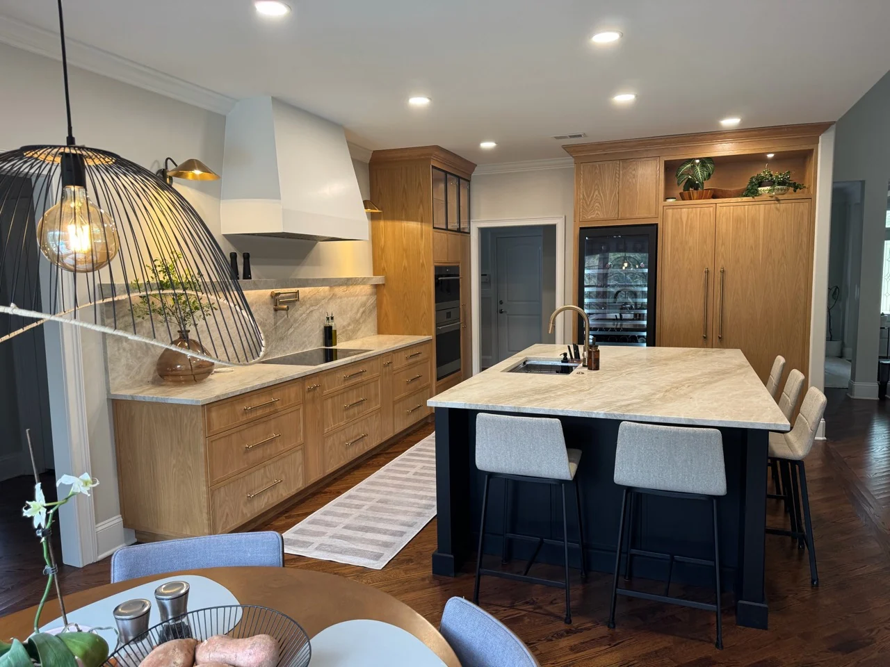Wood kitchen cabinetry and island viewed from the breakfast area